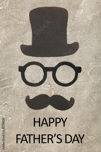 Happy Father's Day. Bowler hat, glasses and mustache on grey background