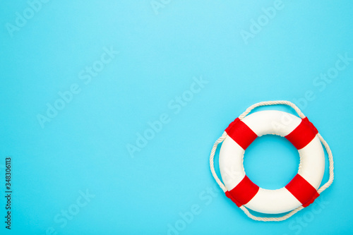 Red-white lifebuoy on blue background. Copy space