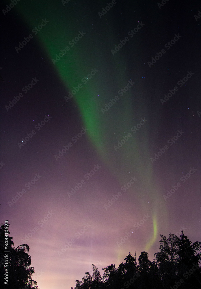 the sky is covered with greenish flashes of Aurora Borealis