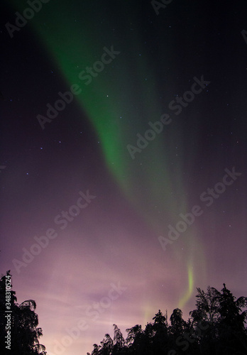 the sky is covered with greenish flashes of Aurora Borealis