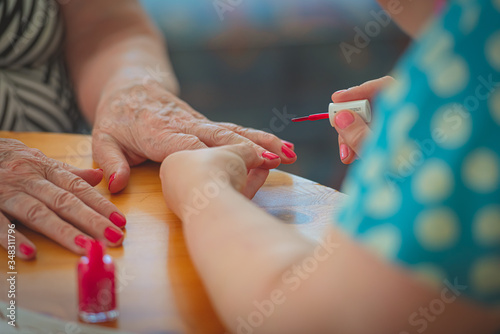 Stampa su tela Freshly paintet red nails on an old woman
