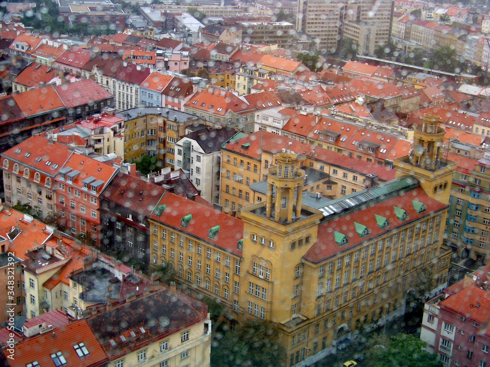 The Prague panorama shot with rain drops on the window of the TV tower with many famous city sights and red roofs