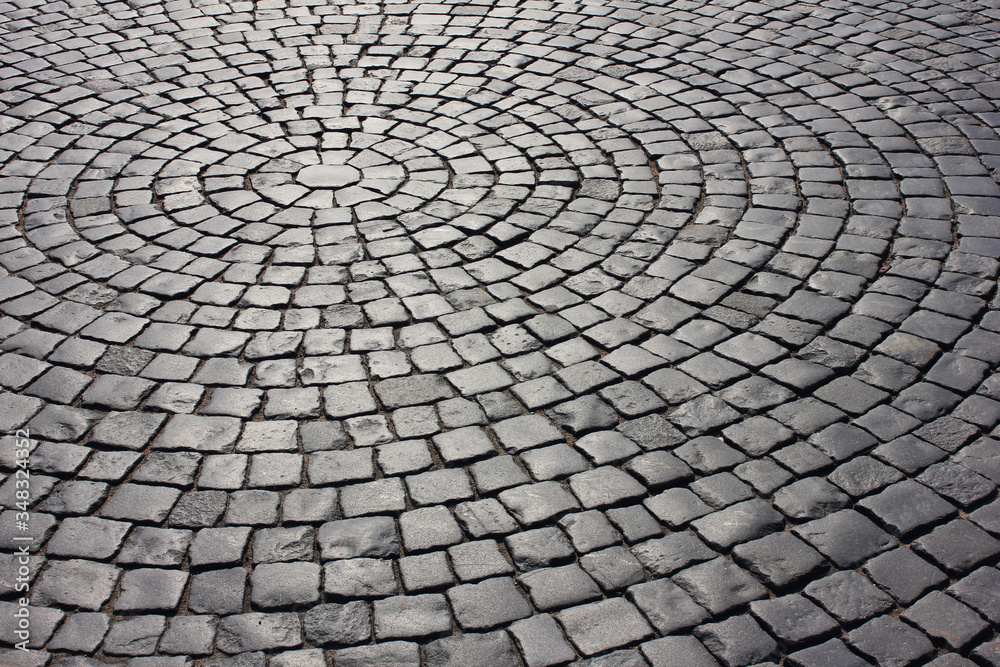 Brick cobblestone pavement pattern rocky pathway close up background. Empty dark stone street pavement, abstract gray cobblestone paved road pattern with no people