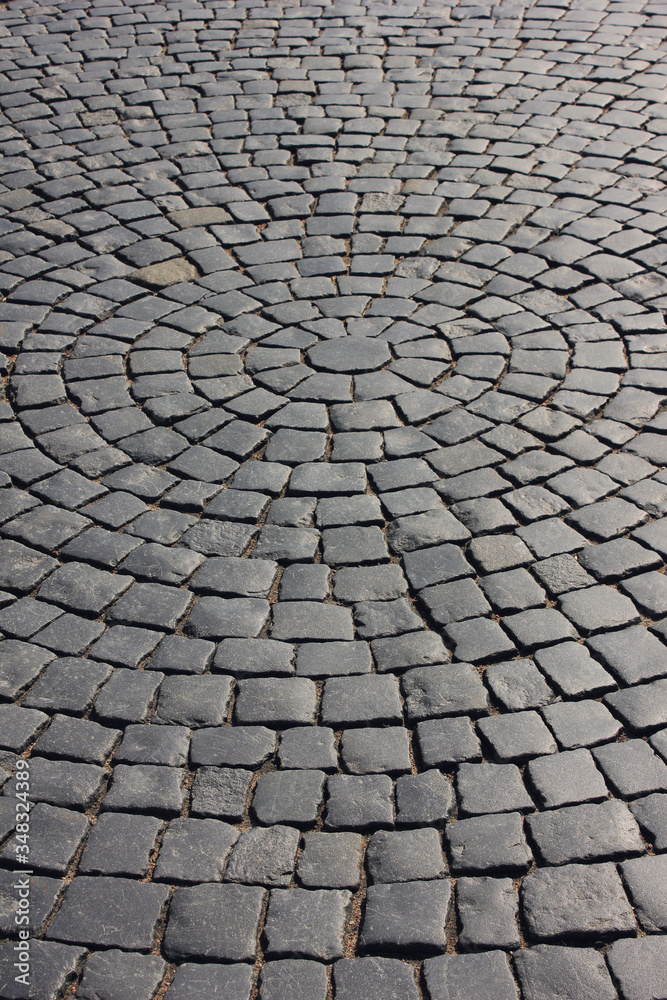 Cobblestone pavement close up pattern on old town street. Rough stone pavement, empty cobbled city road with no people. Cobble stone street detail, empty paved avenue and pathway closeup view
