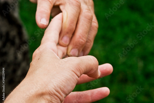 Old and young hands close-up. Old, good grandmother's hands close-up. Aged maternal hands with the hands of young children. Caring for old people. Care and love for elderly parents © Pavlo