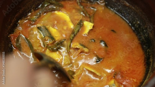 Meen Vattichathu or Pattichathu, sardine fish cooked. Traditional hot and spicy fish curry Kerala India with dried red chilly and green curry leafs. Very popular coastal food eat with tapioca or rice photo