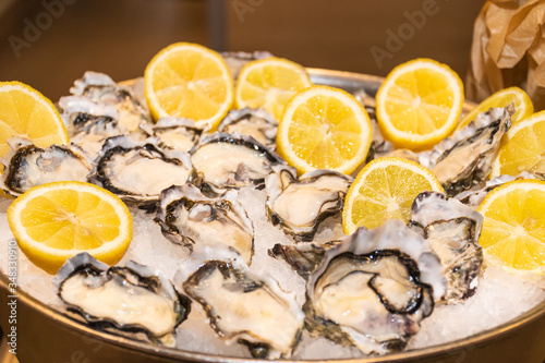 Fresh Fine de Claire Oysters served with lemon's slices in ice, durign brunch buffet.