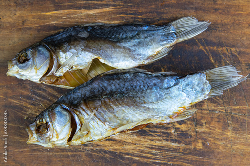 Dried salted crucian fishes on wooden background. Snack to beer photo