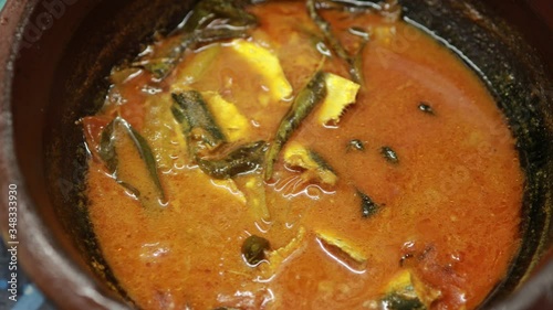 Meen Vattichathu or Pattichathu, sardine fish cooked. Traditional hot and spicy fish curry Kerala India with dried red chilly and green curry leafs. Very popular coastal food eat with tapioca or rice photo