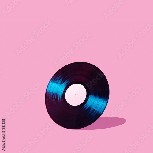 Shiny LP vinyl record lit with blue and red colorful neon light on abstract background with copy space