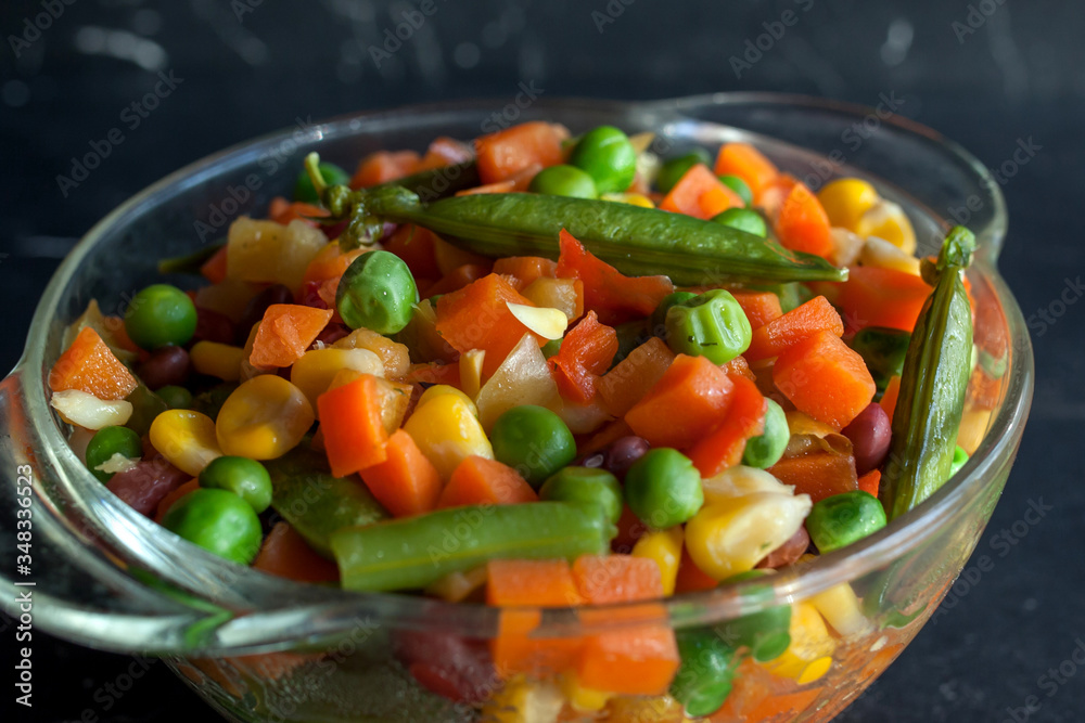 steamed vegetables on plate at dark background