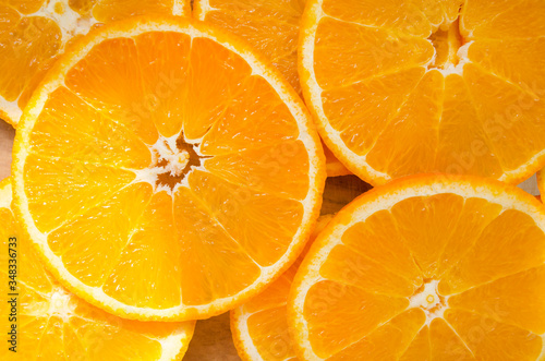 Pattern made with slices of juicy orange with tough sunshine spots, top view