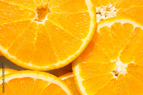 Pattern made with slices of juicy orange with tough sunshine spots, top view