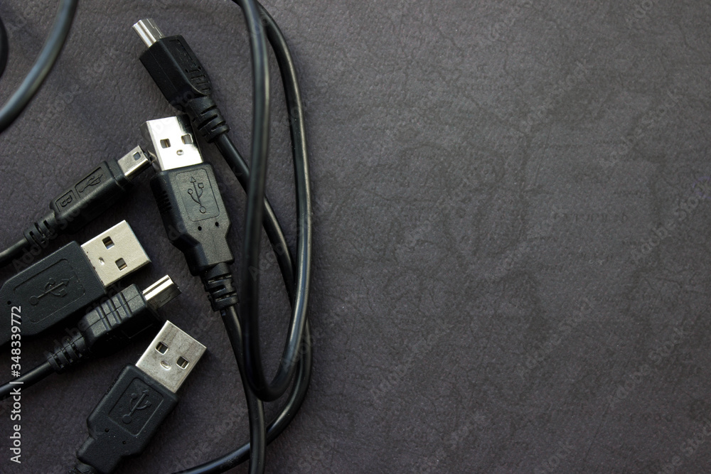 Close up USB and mini USB cables on black background with place for your design Close up USB and mini USB cables on black background with place for your design