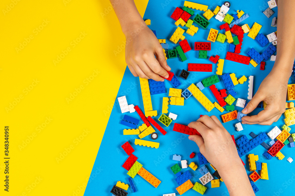 Obraz premium Vilnius, Lithuania - February 23, 2019. Children hands play with colorful lego blocks on the table