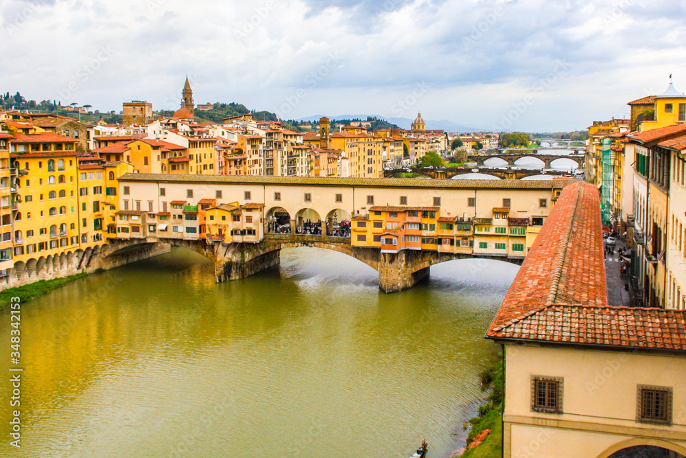 Fototapeta Veduta di Ponte Vecchio sul fiume Arno, Firenze, Italia, con cielo nuvoloso.