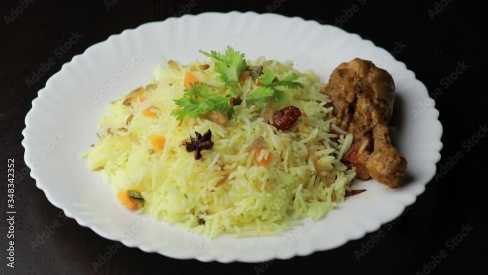 Chicken Biryani showing leg piece - It's a delicious recipe of Basmati rice mixed with with spicy marinated chicken in a bowl. Served in a bowl or plate. Selective focus	