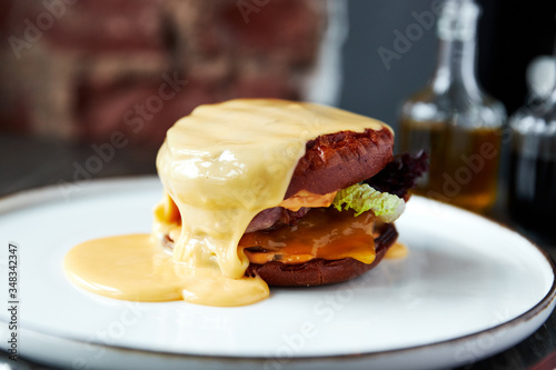 cheeseburger, burger with lots of cheese she has a white plate