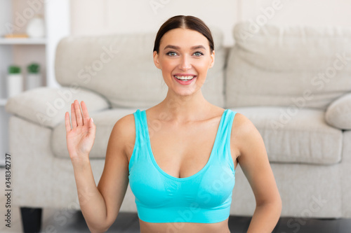Fitness Girl Waving Hello Smiling To Camera Sitting Indoors Free Download Fitness Girl Waving Hello Smiling To Camera Sitting Indoors - GFXLoad