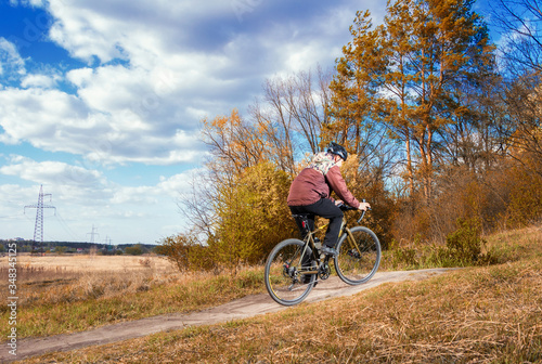 Gravel bike. Cyclist on a gravel bike rides along a path into the forest. Active lifestyle.