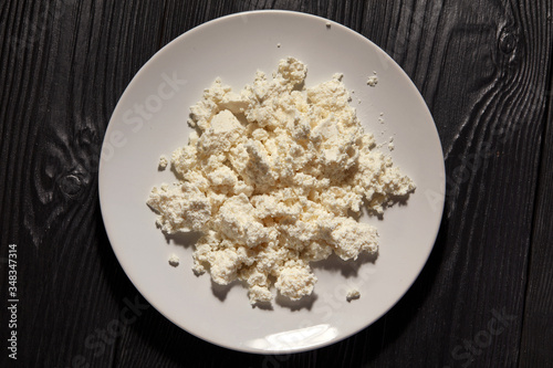Homemade cottage cheese in a bowl on old wooden table