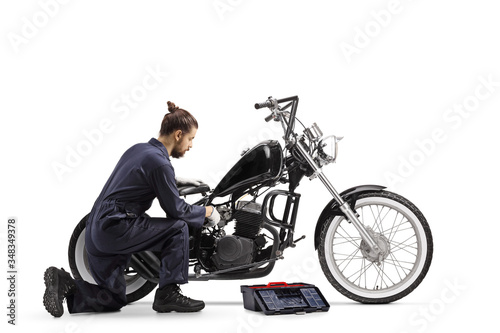 Motorcycle mechanic with a tool box repairing a chopper motorbike