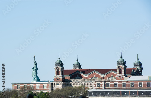 Side view of statue of liberty and the exterior of ellis island on the Hudson River, taken from the Liberty State Park. photo