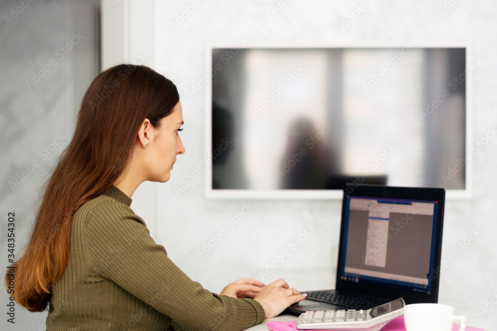 Young woman working on computer at home. Attractive businesswoman studying online, using laptop software, web surfing information or shopping in internet store. Remote work. Freelance Young woman working on computer at home. Attractive businesswoman studying online, using laptop software, web surfing information or shopping in internet store. Remote work. Freelance