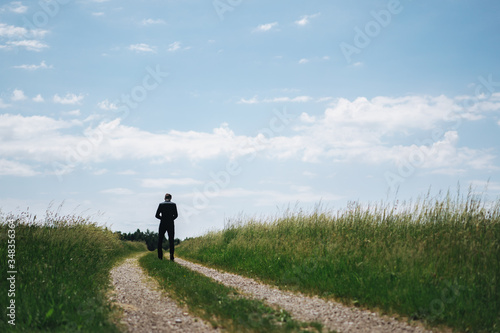 photo of a man standing on a way between two fields © wideeyes