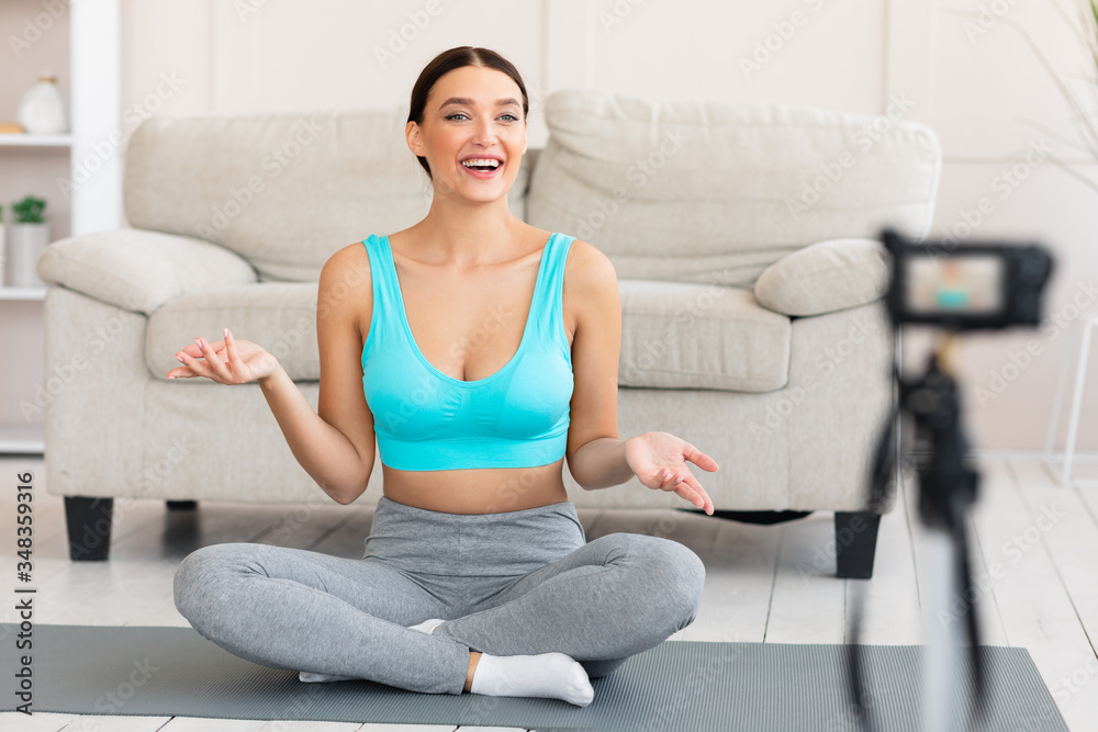 Yoga Teacher Making Video Tutorial Sitting On Mat At Home