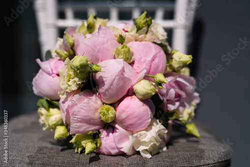 a bouquet of pink peony lies on a chair, a bouquet for the bride, flowers, fragrant peonies in buds,