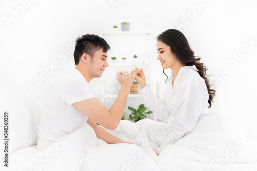 close up woman, asian lover relax in bedroom, woman use pinkie finger holding pinkie finger of man, they feeling happy in honeymoon time, happiness valentine's day