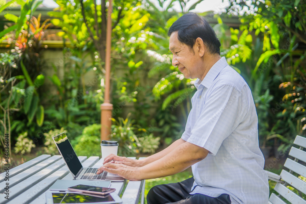 Portrait of old man sitting on couch and using laptop Portrait of old man sitting on couch and using laptop