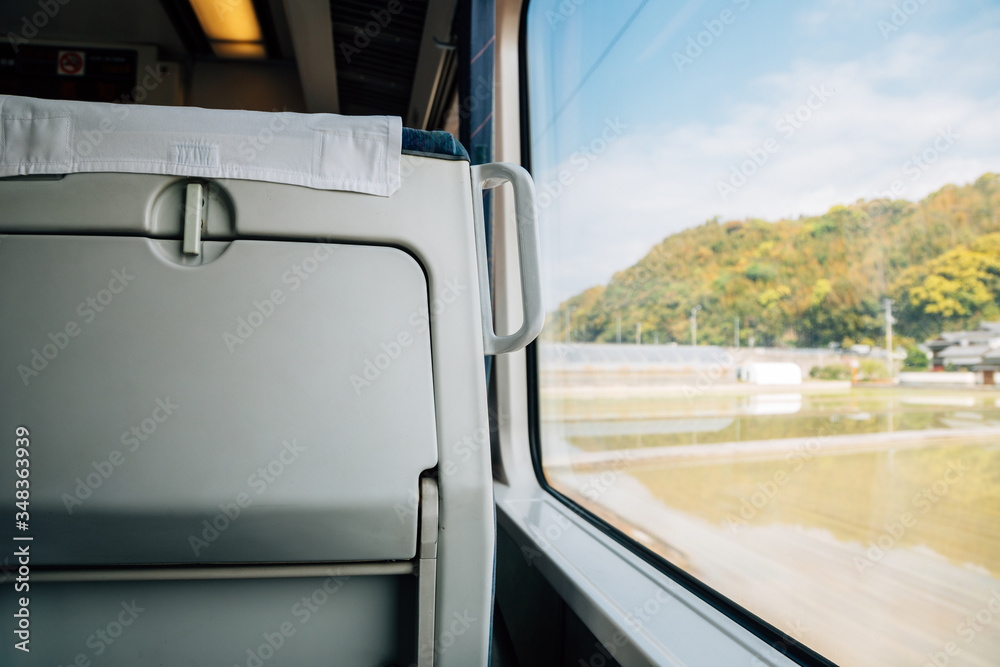 Inside of Japanese train with rural scenery over the window