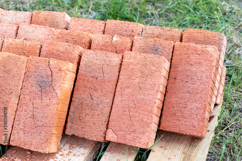 Racks with full-bodied bricks. Several pallets of red bricks are stacked on top of each other. Material for brickwork.