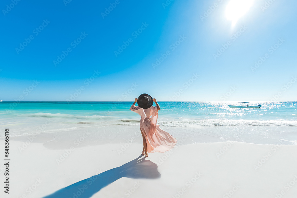 Woman enjoying sunny day on the tropical caribbean sandy beach landscape with turquoise sea and blue sky Woman enjoying sunny day on the tropical caribbean sandy beach landscape with turquoise sea and blue sky