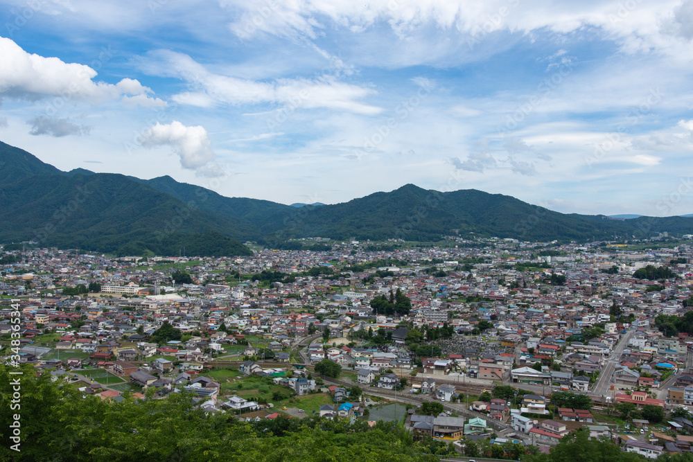 Scenic view of Japanese town surrounded by mountains with blue sky background