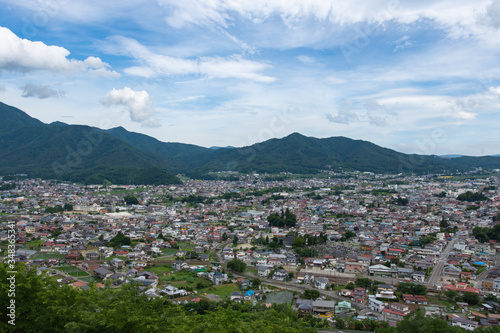 Scenic view of Japanese town surrounded by mountains with blue sky background