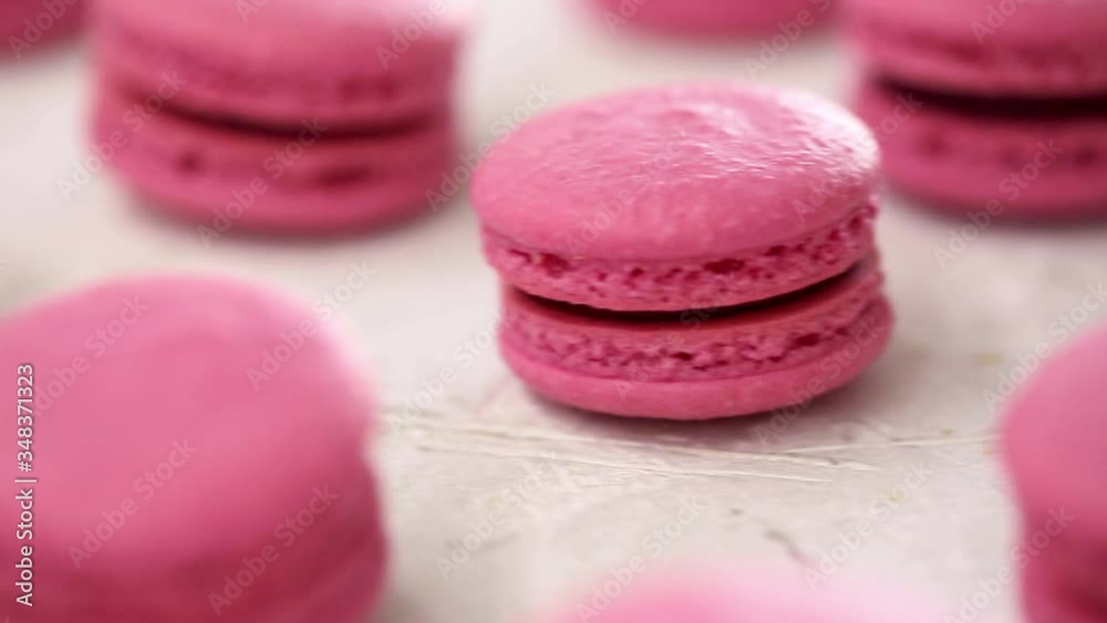 Close-up view of many rows of pink macarons macaroon on white background. Classical French dessert. Close-up view of many rows of pink macarons macaroon on white background. Classical French dessert.