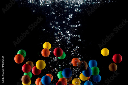 colored balls falling into the water and splashing