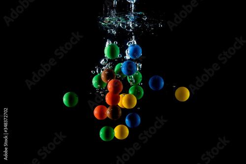 colored balls falling into the water and splashing
