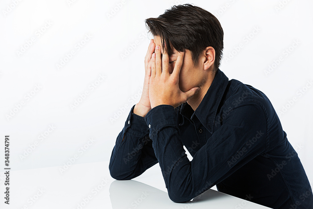 顔を覆う男性 顔を覆う男性