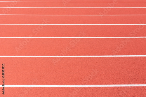 Empty track and field race course lanes. No numbers. Side view.