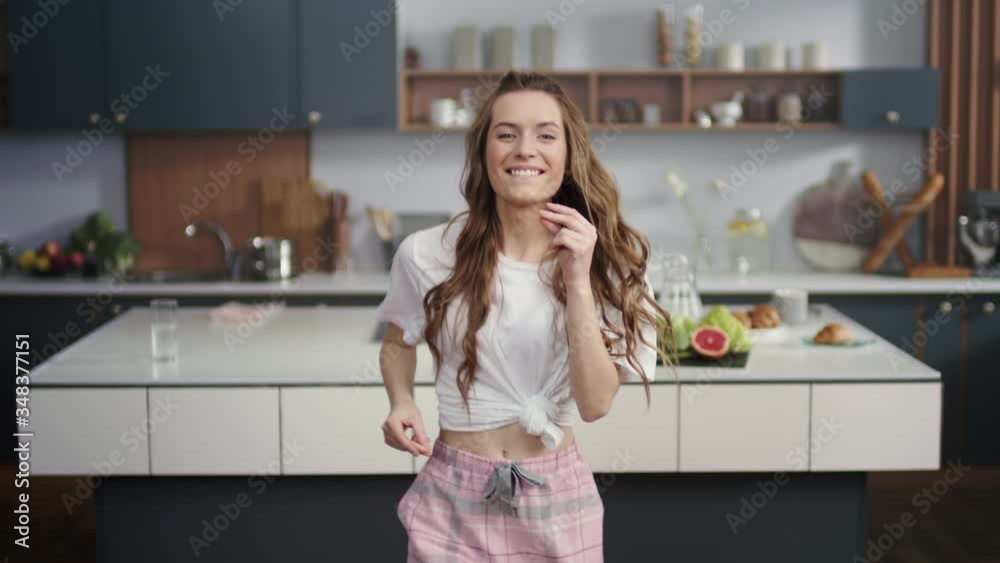 Energetic woman dancing on modern kitchen. Smiling girl snapping fingers at home Energetic woman dancing on modern kitchen. Smiling girl snapping fingers at home