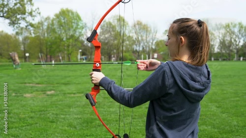 HD footage of girl shooting a bow and arrow at an archery range in slow motion photo