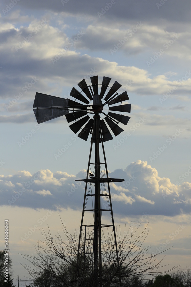 Kansas Country Windmill with clouds at Sunset out in the country. Kansas Country Windmill with clouds at Sunset out in the country.