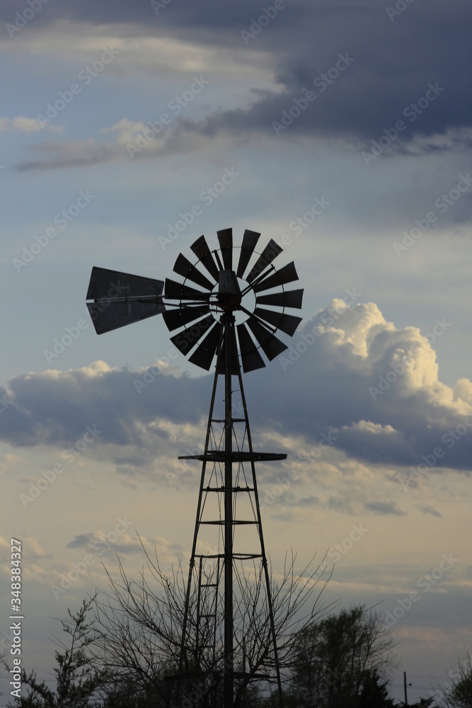 Kansas Country Windmill with clouds at Sunset out in the country. Kansas Country Windmill with clouds at Sunset out in the country.