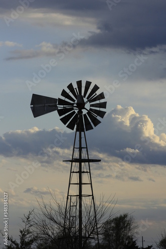 Kansas Country Windmill with clouds at Sunset out in the country.