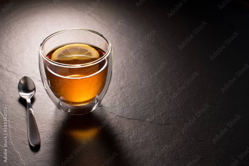 Cup of tea with lemon on black granite background Cup of tea with lemon on black granite background
