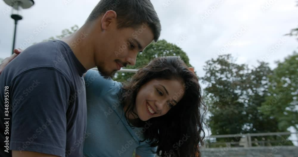 Boyfriend and girlfriend smiling and looking at smartphone after workout. Boyfriend and girlfriend smiling and looking at smartphone after workout.